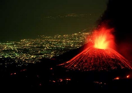 volcan en éruption lave rouge la nuit ville lumières